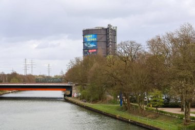 Oberhausen, Almanya - 30. Mart 2025: Ren-Herne Kanalı köprünün altından geçiyor ve arkada Oberhausen, Almanya