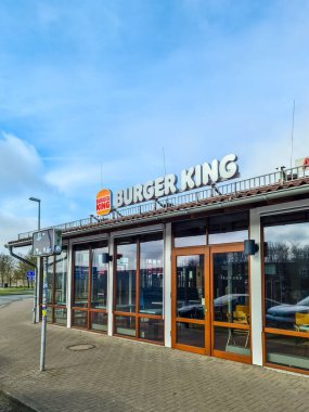 Hamburg, Almanya - 28. Mart 2024: Burger King restoranının dışı güneşli bir günde ışıklı bir tabela ile markanın varlığını gösteriyor