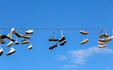 Flensburg, Almanya 'da bir sürü spor ayakkabısı mavi gökyüzüne karşı sallanıyor.