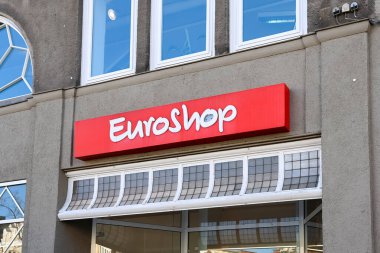 Flensburg, Almanya 'da bir binanın üzerinde parlayan kırmızı Euroshop logosu uygun fiyatlı alışveriş seçeneklerini temsil ediyor ve müşterileri çekiyor.