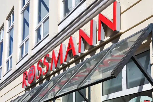 Flensburg, Almanya 'da bir binanın ön cephesinde parlayan kırmızı Rossmann logosu gündüz vakti parlak güneş ışığı altında yayılıyor.