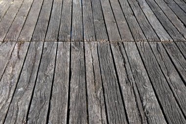 Paralel yıpranmış ahşap kalaslar, yaş ve elementlere maruz kalma belirtileri gösteren dokulu bir yüzey oluşturur.