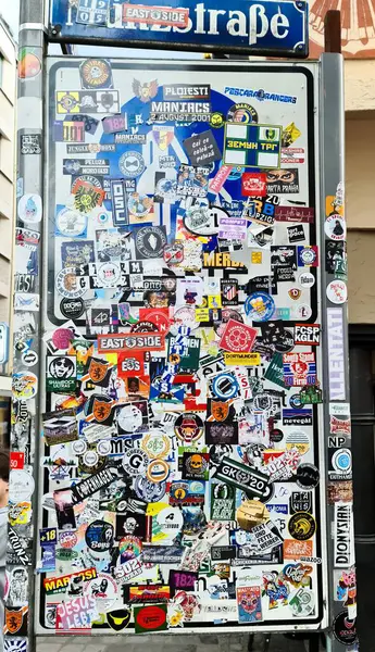 Münih, Almanya - 22. Haziran 2024: Almanya 'nın Münih kentsel sanat ve çeşitli alt kültürleri yansıtan kaotik çıkartmalarla kaplı sokak tabelası