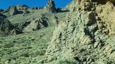Engebeli volkanik kaya oluşumları Teide Ulusal Parkı, Tenerife 'deki yeşil dağlık çalılıkların arasında Kanarya Adaları' nın ham jeolojik güzelliğini yakalıyor.