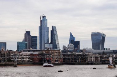 Londra, Birleşik Krallık - 04. Ekim 2024: Thames Nehri 'nin karşısından bakıldığında Londra' nın gökdelenlerine hakim olan modern gökdelenler, kentsel gelişimin ve mimari dehanın altını çiziyor