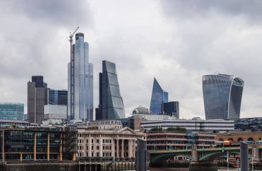 Londra, Birleşik Krallık - 04. Ekim 2024: Modern gökdelenler ve inşaat vinçleri Londra 'daki geleneksel binaların üzerinde bulutlu bir gökyüzünün altında yükseliyor