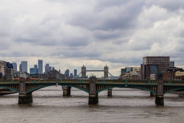 Londra, Birleşik Krallık - 04. Ekim 2024: Londra 'nın panoramik manzarası Tower Bridge ve Thames Nehri üzerindeki dramatik bulutlu bir gökyüzü altında bir köprü
