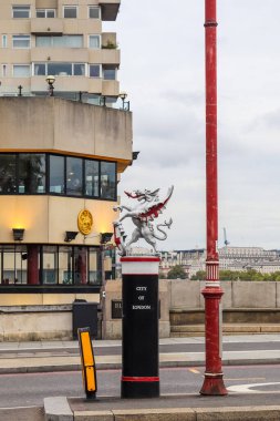 Londra, Birleşik Krallık - 04. Ekim 2024: Londra şehrinin ejderha sınırı kırmızı bir sokak lambasının yanında siyah, beyaz ve kırmızı bir direğin üzerinde duruyor