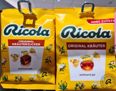 Kiel, Almanya - 19. Nisan 2025: Bir süpermarkette rafta asılı duran, şekersiz ve orijinal aromalı Ricola İsviçre sebze tatlısı paketleri