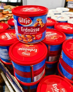Kiel, Almanya - 19. Nisan 2025: Bir süpermarketin rafında üst üste istiflenmiş Itje Erdnsse baharatlı fıstık konserveleri satın alınmaya hazır 