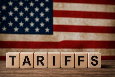 ABD bayrağının bulanık arkaplanına karşı ahşap küpler oluşturarak ticaret ve ekonomik temaları vurguluyor.