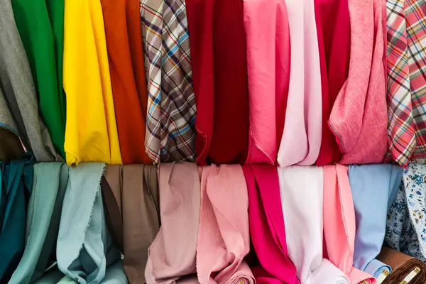 Birçok renkli kumaş bir mağazada asılı, tekstil endüstrisi, perakende ve moda tasarımları için mükemmel.