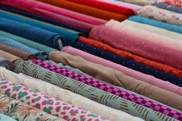 Renkli kumaşların çoklu cıvataları düzenli olarak düzenlenir, çeşitli doku ve tasarımlar projeler için idealdir.