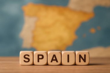 Ülkenin yumuşak ve bulanık bir haritası önünde İspanya 'yı oluşturan tahta küplerin coğrafi cazibesini ve seyahat cazibesini vurguluyor.