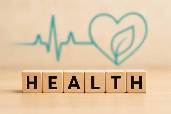 Sağlıklı kelimesini içeren dört tahta küp, bulanık bir kalp atışı sembolü ve içinde yaprak olan bir kalp.