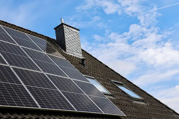 Fotovoltaik paneller, baca ve tavan penceresinin yanı sıra sürdürülebilir ve yeşil enerji sağlayan bir çatıya kurulur.