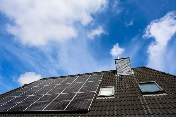 Çatıya kurulmuş fotovoltaik paneller temiz ve sürdürülebilir enerji sağlayarak parlak mavi gökyüzü altında daha yeşil bir geleceğe katkıda bulunuyor.
