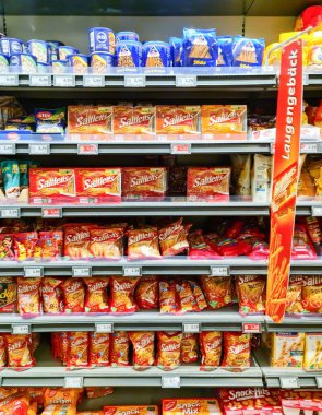 Kiel, Almanya - 28. Mayıs 2025: Süpermarket raflarında sergilenen çeşitli tuzlu abur cuburlar, Almanya 'nın Kiel kentindeki müşterilere geniş bir seçenek sunuyor