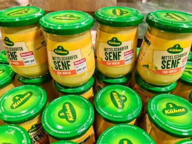 Kiel, Almanya - 28. Mayıs 2025: Yeşil kapaklı Khne mitelscharfer Senf 'in sayısız kavanozu, çarpıcı bir perakende ekran için düzenli olarak istiflenmiştir  