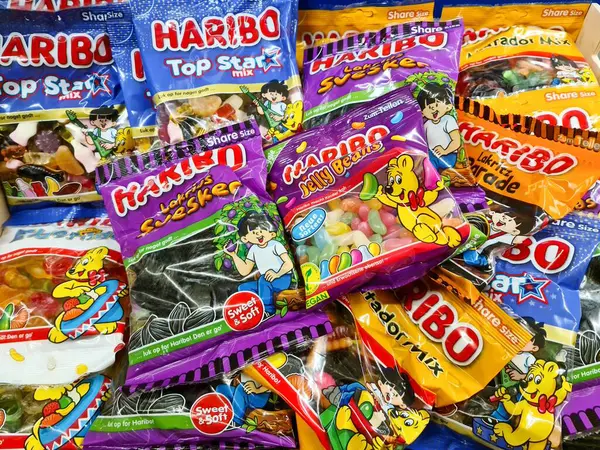 Kiel, Almanya - 28. Mayıs 2025: Renkli plastik torbalarda farklı türde Haribo şekerler, canlı ve cezbedici bir görüntü yaratıyor