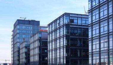 Almanya 'da Kiel' de bulunan pencerelere cam ve güneş ışığı yansıtan modern ofis cepheleri.