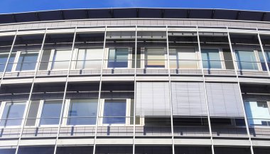 Almanya 'da Kiel' de bulunan pencerelere cam ve güneş ışığı yansıtan modern ofis cepheleri.
