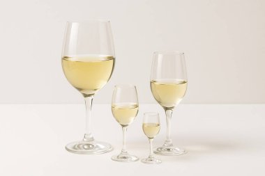 Beyaz bir masanın üzerinde duran dört kadeh beyaz şarap bir aileyi temsil ediyor.