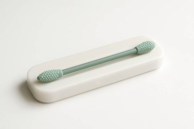 Minimalist seramik tabanda yeniden kullanılabilir silikon çubuk içeren çevre dostu kulak temizleme çözeltisi, sürdürülebilir kişisel bakım uygulamalarını vurguluyor
