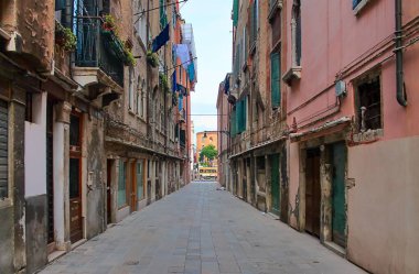 Venedik, İtalya - 24 Mayıs 2024: Venedik, İtalya 'da eski binaları ve asılmış çamaşırları olan boş asfalt cadde