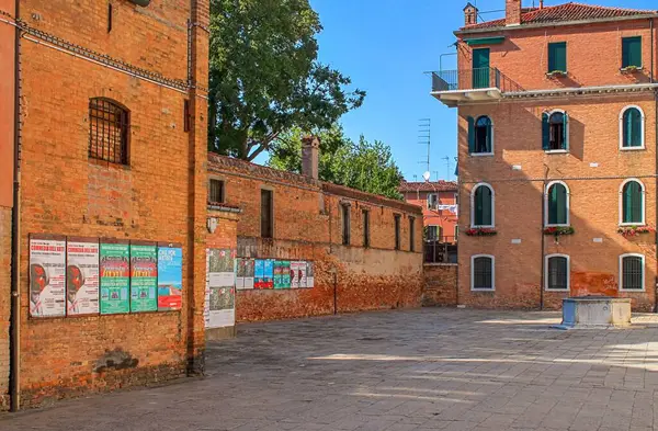 Venedik, İtalya - 24 Mayıs 2024: Venedik, İtalya 'da bir meydanda tuğla bir binanın duvarında asılı posterler