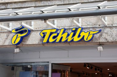 Flensburg, Almanya - 13. Haziran 2025: Sarı ve mavi ışıklı Tchibo tabelası Flensburg 'daki bir mağaza girişinin üzerinde asılı