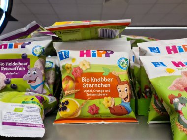 Kiel, Almanya - 18. Haziran 2025: Renkli Hipp organik bebek maması kesesi, bir su aygırı ve bir maymunun yer aldığı, bir mağaza rafında satılmaya hazır şekilde oturuyor