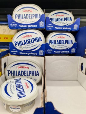 Kiel, Almanya - 18. Haziran 2025: Popüler bir krem peynir markası olan Philadelphia krem peyniri paketleri bir süpermarket rafında düzenli olarak düzenlenmektedir.
