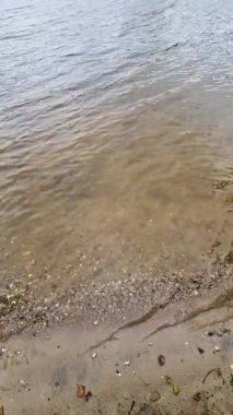 Saf su, kumlu kıyı şeridini usulca silip süpürüyor. Yumuşak dalgalar ve sakin deniz manzarasıyla huzurlu doğal manzarayı gözler önüne seriyor.