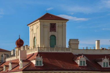 Eisenstadt, Avusturya - 12. Temmuz 2025: Mavi gökyüzü altında kırmızı soğan kubbesi, güneş saati ve bacaları olan Esterhazy Sarayı 'nın mimari ayrıntıları