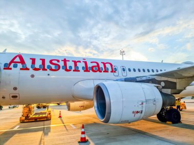 Viyana, Avusturya - 12. Temmuz 2025: Avusturya Havayolları Airbus A320 güzel bir günbatımı, seyahat ve turizm sektöründe havaalanına park ediyor