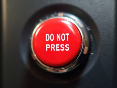 Sözcüklerin yazılı olduğu büyük kırmızı düğmeye yakın çekim yapmak uyarı ve entrika hissi yaratır.