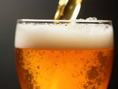 Altın biranın bardağa dökülmesi köpüklü bir kafa ve kabarcıklar yaratır.