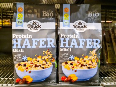 Kiel, Almanya - 09. Ağustos 2025: Bauck Mhle tarafından hazırlanan vegan protein yulaf ezmesi paketleri bir süpermarket rafında sergilenerek sağlıklı beslenme seçeneklerini destekliyor 