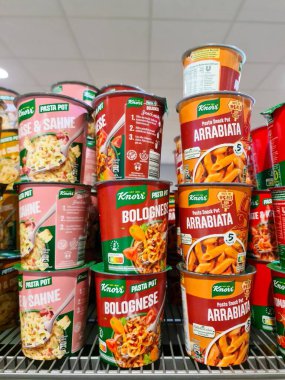 Kiel, Almanya - 18. Ağustos 2025: Arrabbiata, Bolonez ve Cheese & Sahne gibi tatlarda Knorr hazır makarna kapları bir süpermarketin rafında güzelce istiflendi