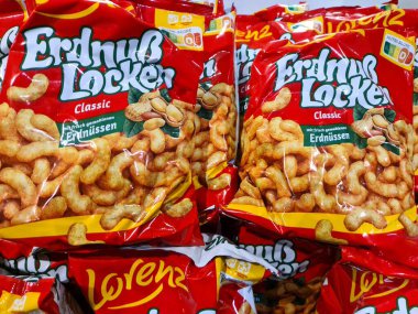 Kiel, Almanya - 18. Ağustos 2025: Marketin rafına istiflenmiş kırmızı Lorenz Erdnuss Dolaplı fıstık tabakları satın alınmaya hazır