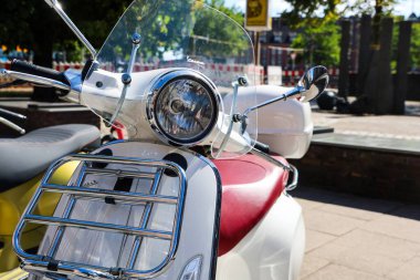Hamburg, Almanya - 23. Ağustos 2025: Hamburg caddesine park etmiş beyaz Vespa scooter, güneşli yaz gününde krom detayları ve klasik tasarımı vurguluyor