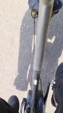 Güneşli asfalt yolda bisiklet süren bisikletçi, kentsel dönüşüm ve aktif ulaşım yoluyla sürdürülebilir kişisel hareketlilik sergiliyor