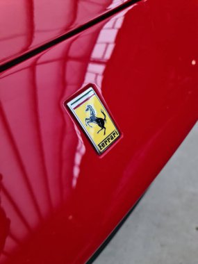 Kiel, Germany - 25. September 2025: Ferrari prancing horse logo emblem on a red sports car