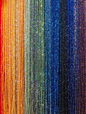 Sparkling colorful beads strung together forming a vibrant rainbow gradient, perfect for abstract backgrounds, craft, or jewelry concepts