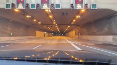 Hamburg, Germany - 25. September 2025: Car driver point of view shot entering and exiting a well-lit road tunnel during the day