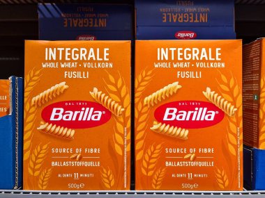 Barilla whole wheat fusilli pasta boxes displayed prominently on a supermarket shelf