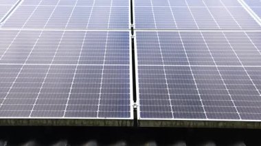 Rows of photovoltaic solar panels on a house rooftop collecting clean renewable energy from the sun with a blue sky in the background