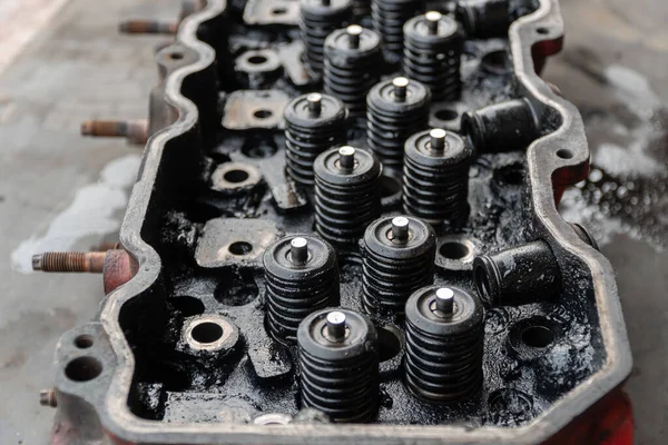 Maintenance inspection of engine valves, engine cylinder head. Repair of engine head and valves. Disassembled machine engine at modern auto service