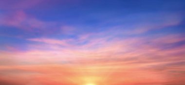 Real amazing panoramic sunrise or sunset sky with gentle colorful clouds. Long panorama, crop it. Evening sky scene with golden light from the setting sun